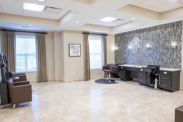A modern and spacious salon interior with chairs and mirrors.