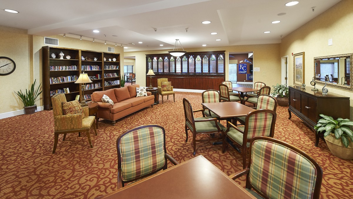 A cozy living area with bookshelves, tables, and comfortable seating.