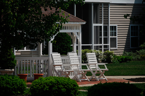 A serene outdoor space featuring white lawn chairs arranged near a gazebo, perfect for relaxation.