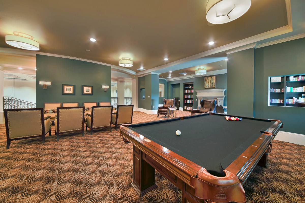 A stylish billiards room featuring a pool table, seating area, and elegant decor.