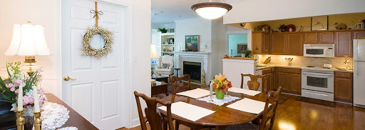 A cozy and inviting dining area with a beautiful table setting, complemented by an adjoining living space featuring a fireplace.