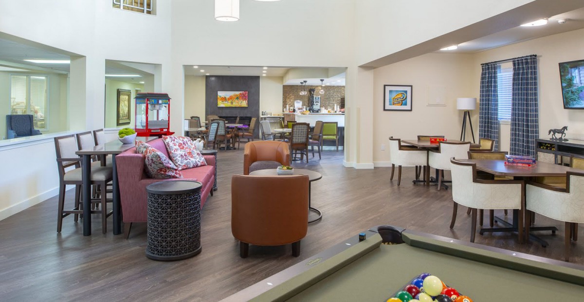 A modern lounge area featuring comfortable seating and a pool table.