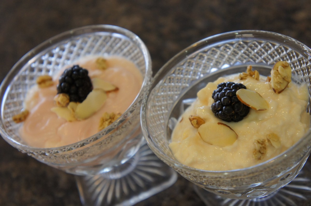 Creamy mousse desserts topped with blackberries and almonds in elegant glass dishes.