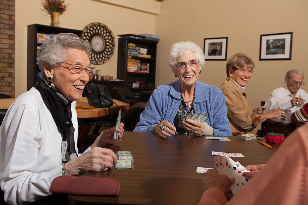 A group of seniors enjoying a card game together indoors.