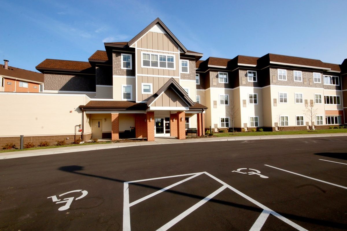 A modern apartment building with a spacious parking lot featuring accessible parking spaces.