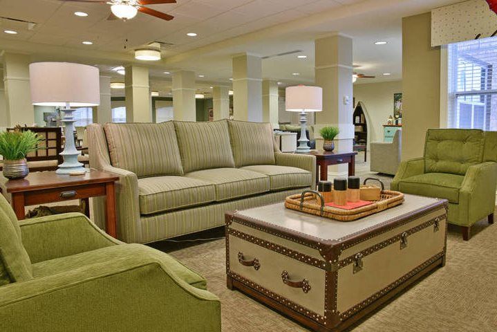 A cozy living room with a sofa, armchairs, and a trunk-style coffee table.