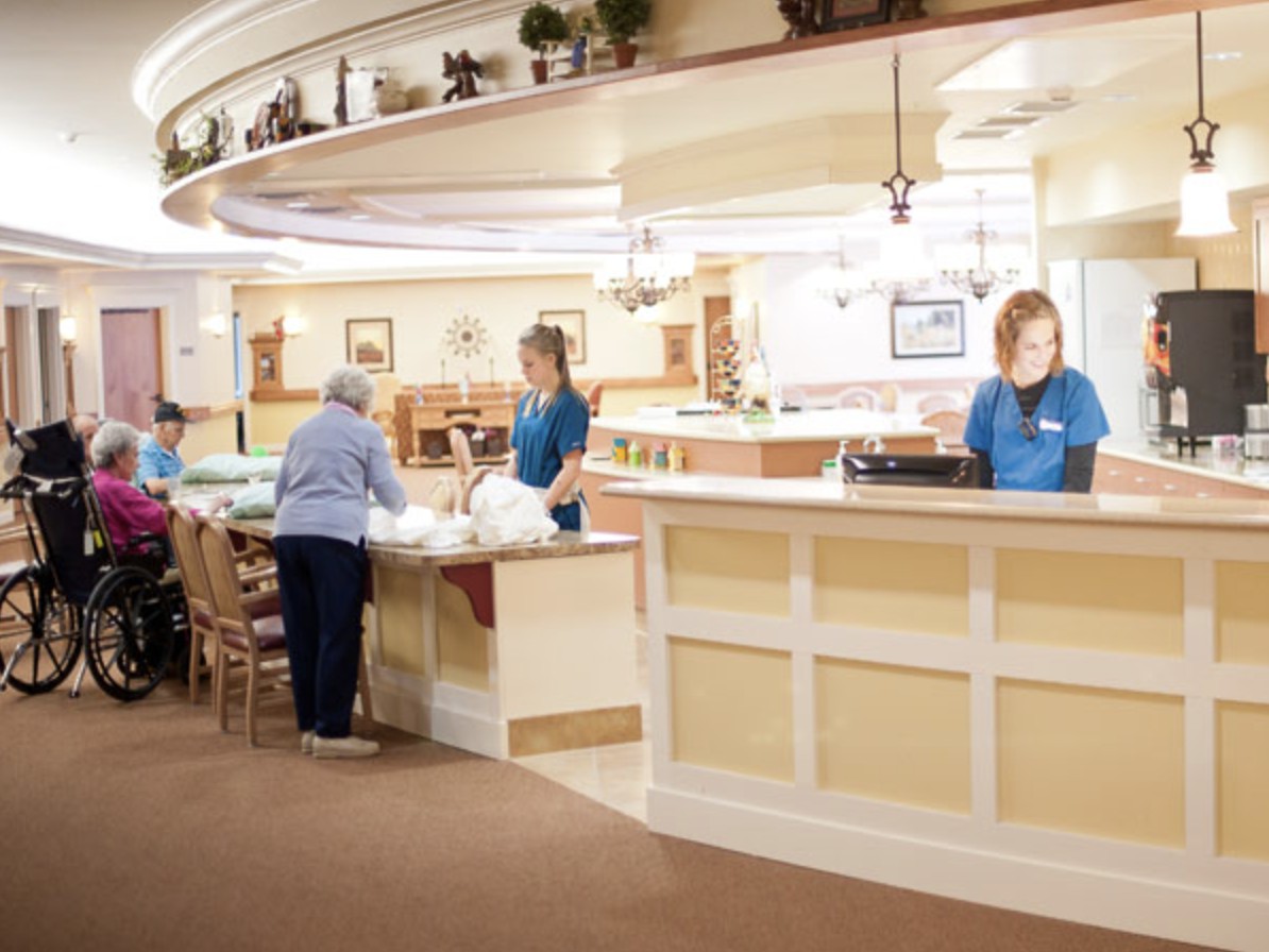 Staff members assisting a visitor at the reception area.