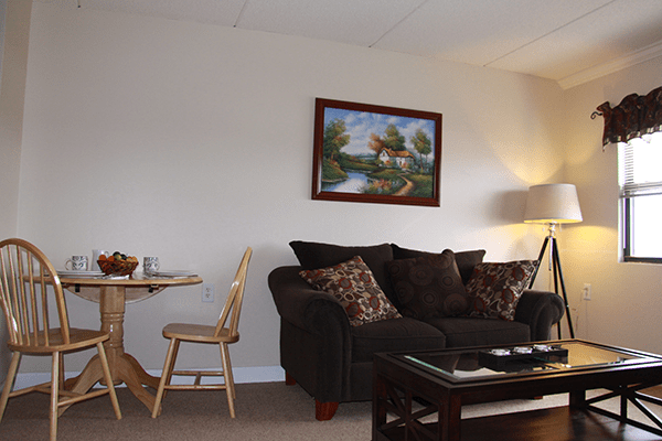 A cozy living room with a sofa, coffee table, and wall artwork.