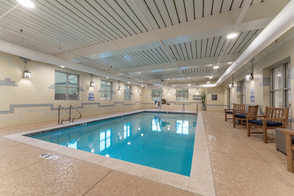 A spacious indoor swimming pool with clean water and surrounding lounge chairs.