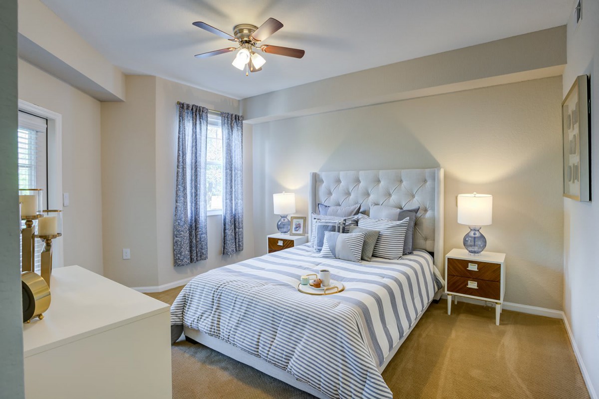 A cozy, elegantly decorated bedroom with a tufted headboard and striped bedding.
