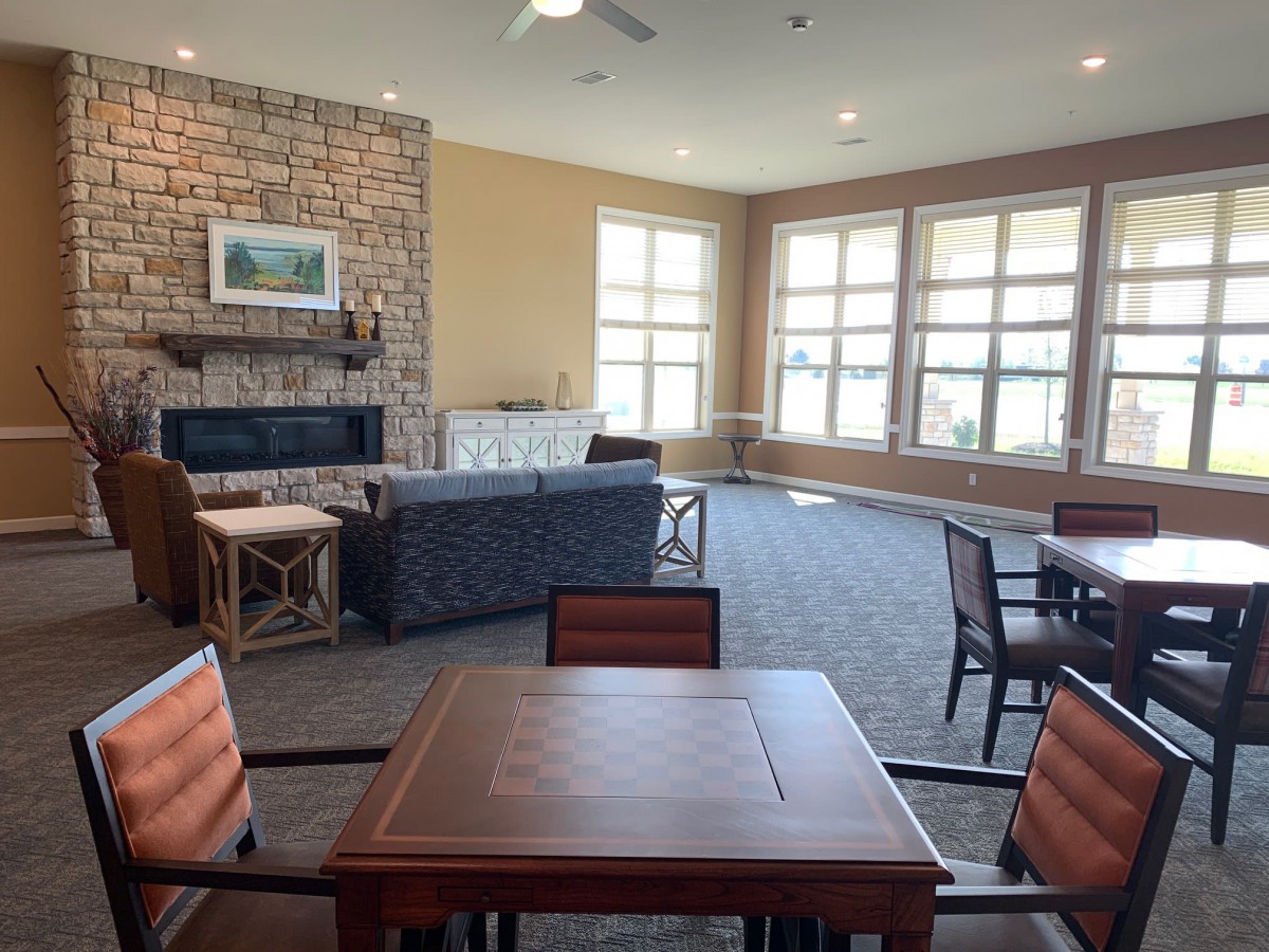 A spacious living room with large windows, comfortable seating, and a fireplace.