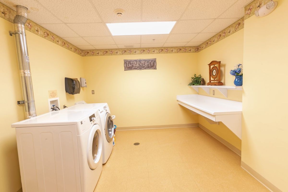 A well-lit laundry room with a washer and dryer.
