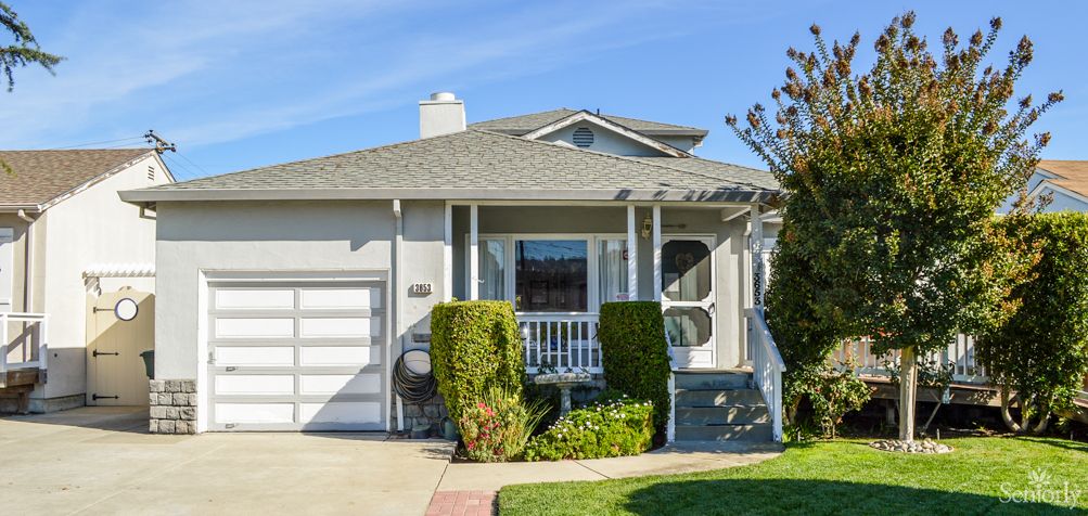 A suburban house with a porch and attached garage.