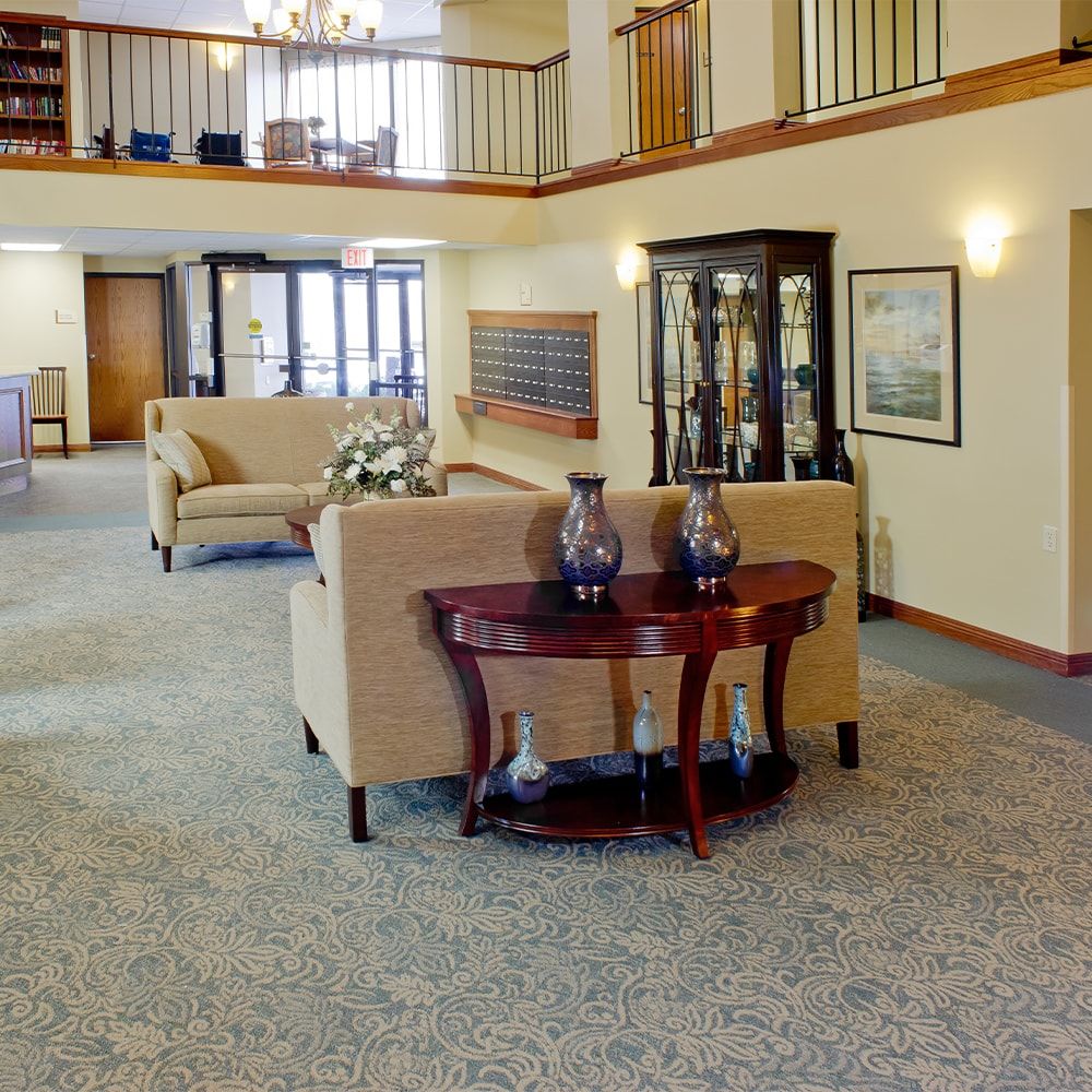 A spacious lobby interior with sofas, a wooden table, and decorative elements.