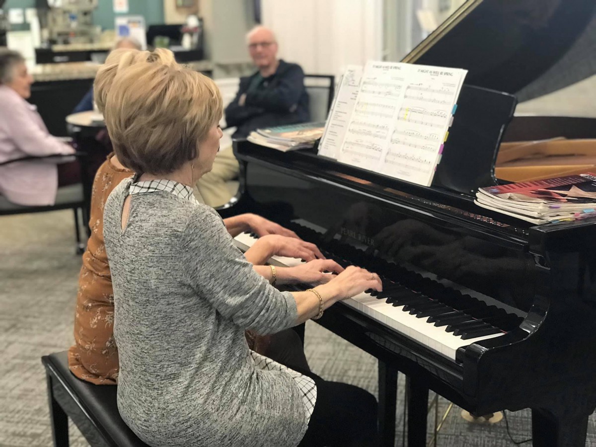 Two people playing a piano duet.