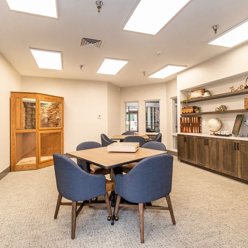 A modern office meeting room with a table, chairs, and decorative shelves.