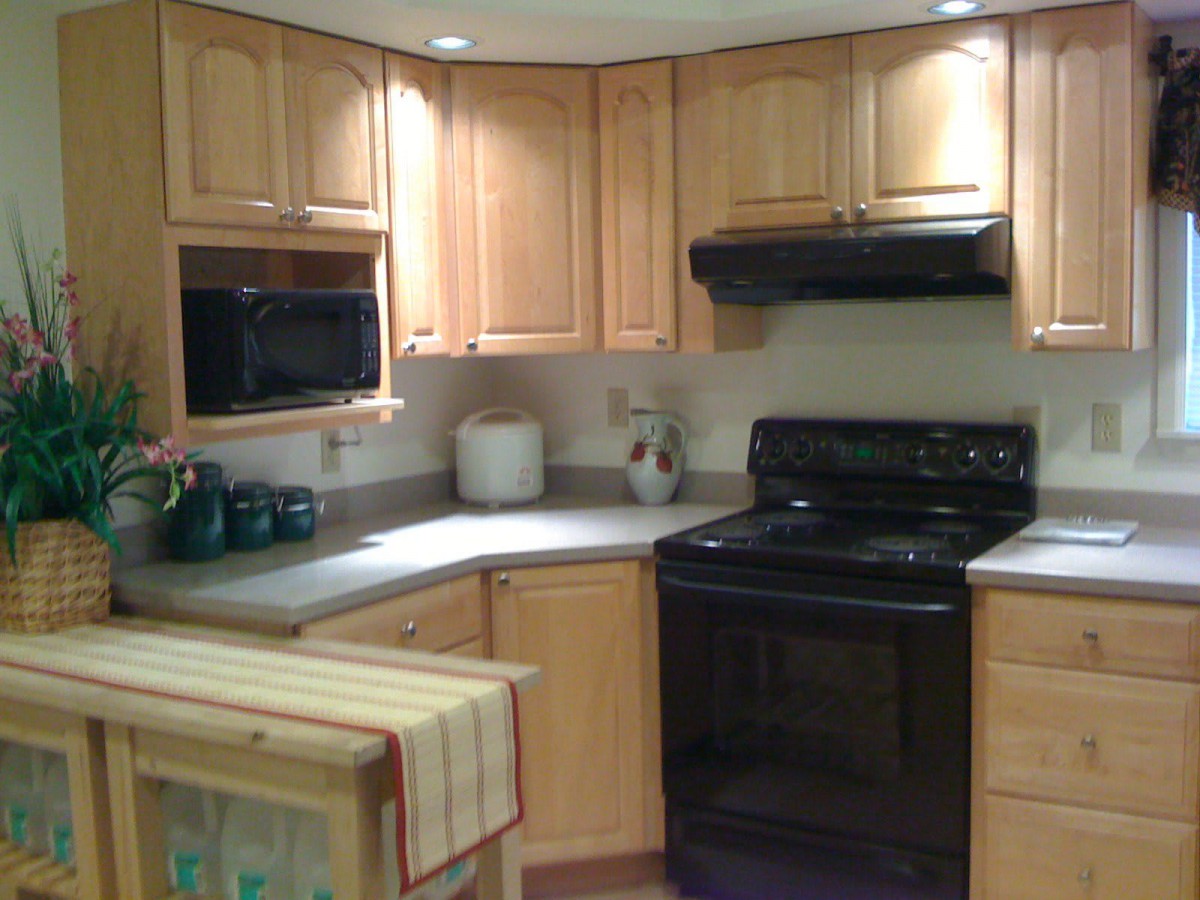 A cozy kitchen with wooden cabinets and black appliances.