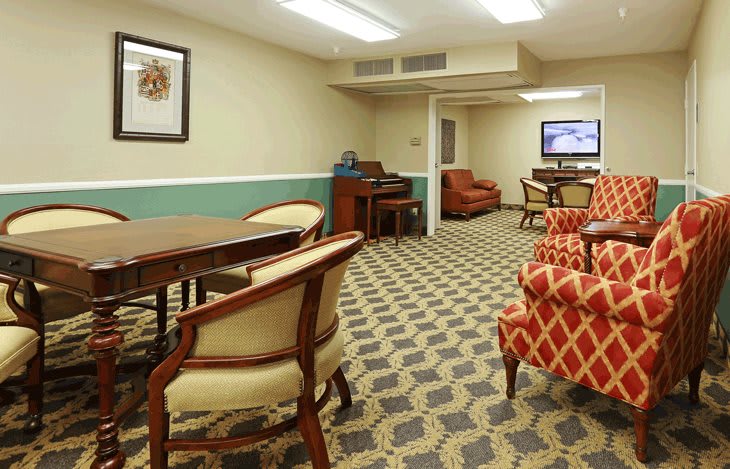 A cozy lounge area with various seating options, tables, and a television.