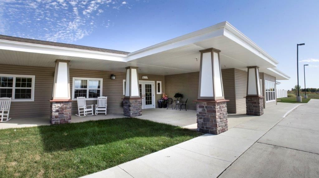 A welcoming building entrance with a covered porch and columns.