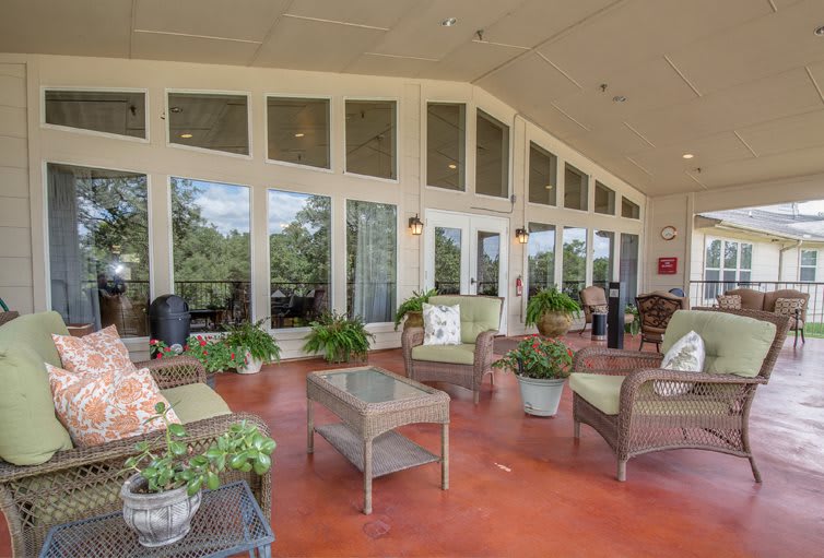 A spacious outdoor patio with comfortable seating and lush greenery.
