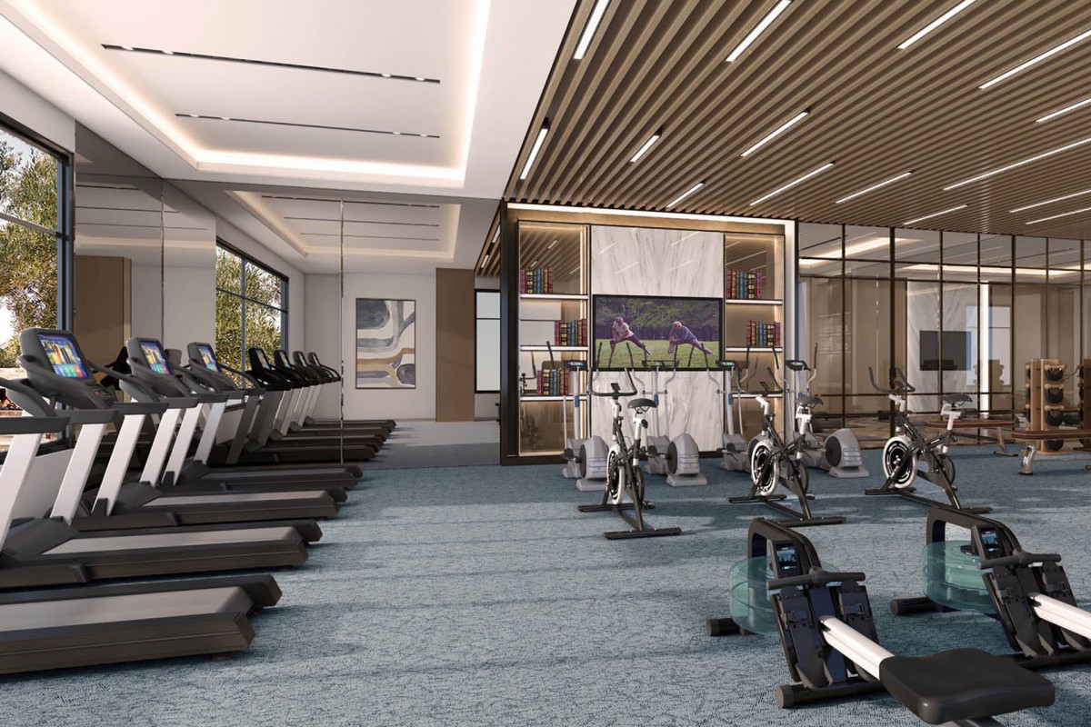 A modern gym with treadmills and exercise bikes in a spacious, well-lit interior.