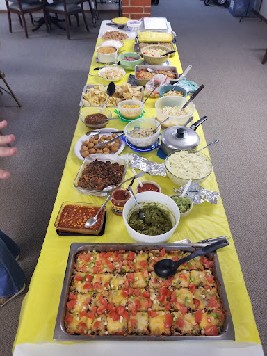 A vibrant buffet spread featuring a variety of delicious dishes served on a yellow tablecloth.