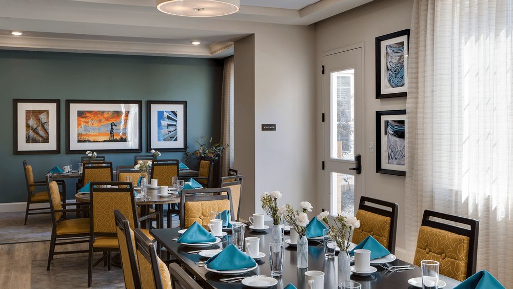 A modern dining room with neatly set tables and contemporary artwork on the walls.