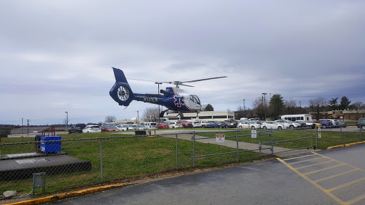 A helicopter in flight over a busy area, possibly related to emergency services.