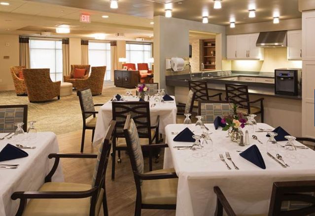 An elegant dining room setup with neatly arranged tables and chairs, featuring a cozy atmosphere.