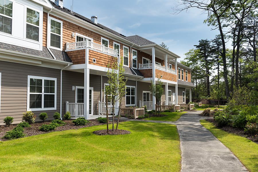 A well-maintained apartment complex with tidy landscaping and a paved pathway.