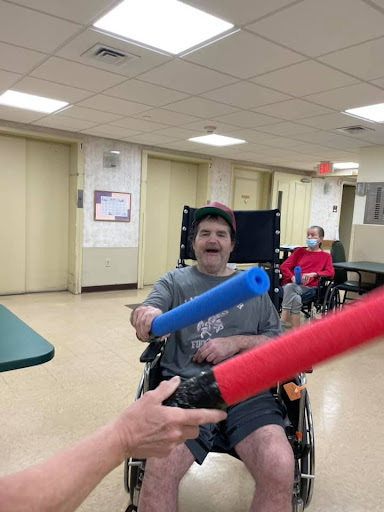 Participants enjoying a fun foam stick activity in an indoor setting.
