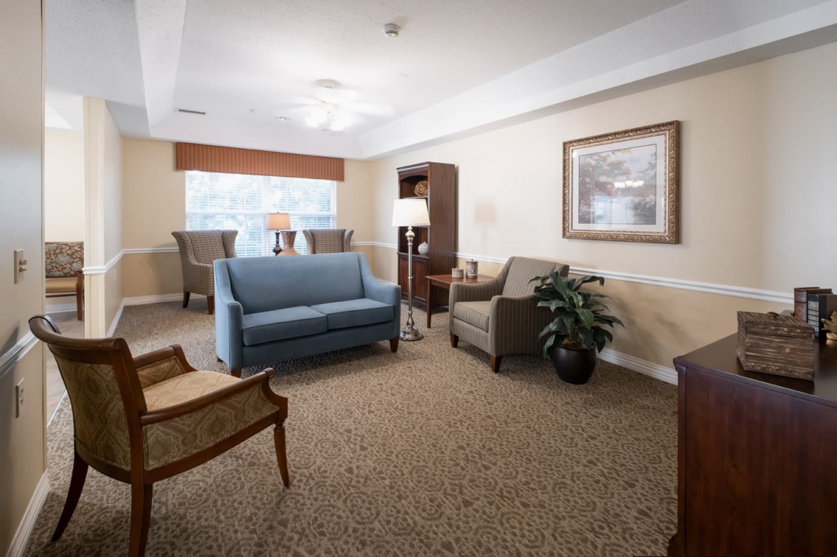 A cozy living room with a blue sofa, chairs, and warm lighting.