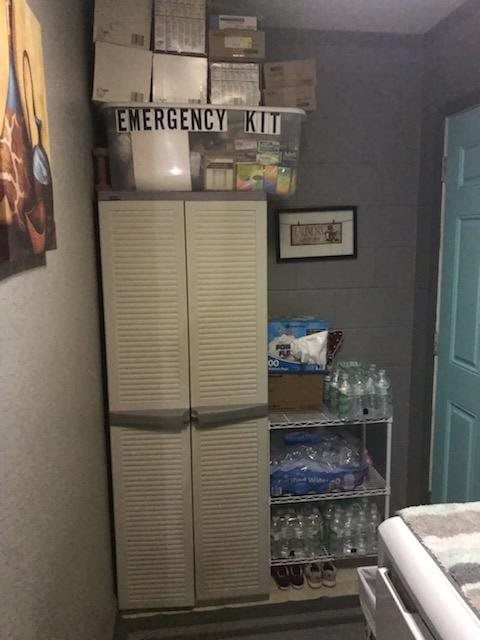 A well-organized emergency kit storage area with supplies and water bottles.