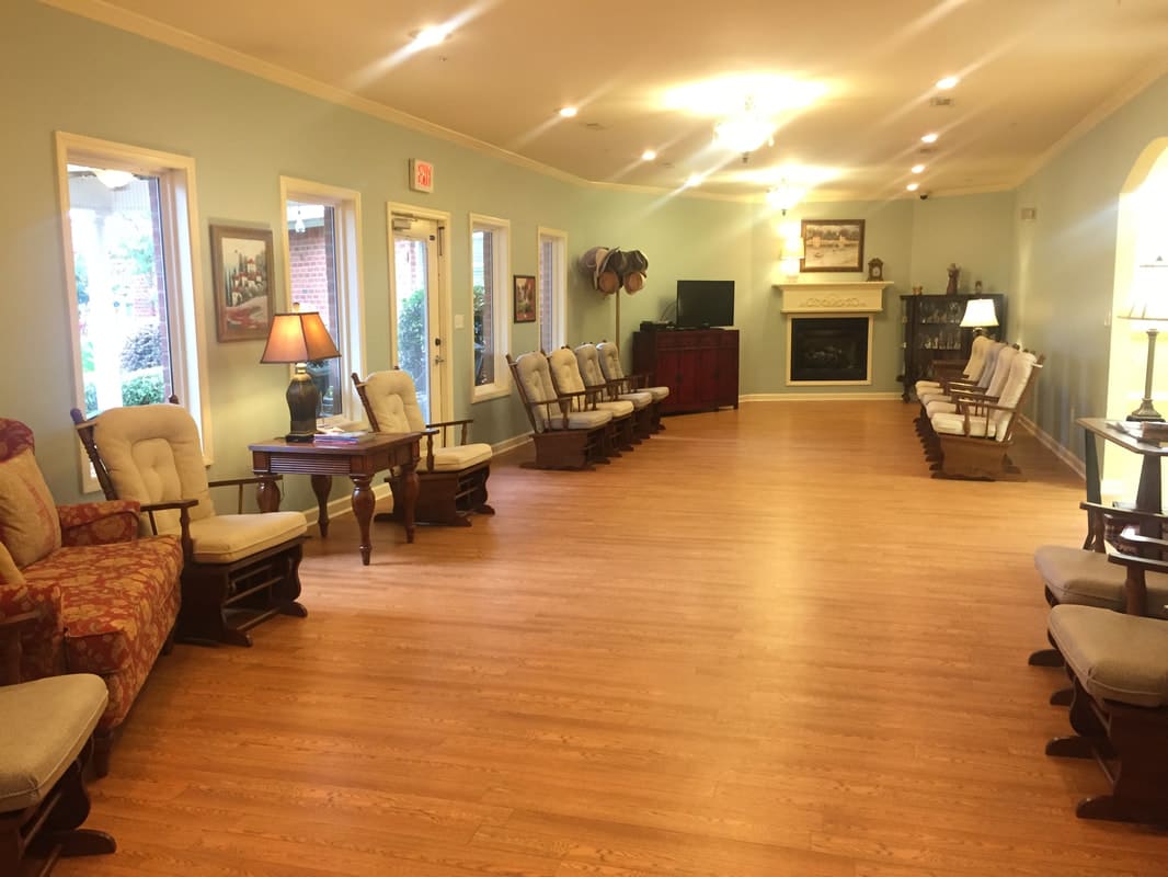 A spacious living room with comfortable seating, lamps, a television, and a fireplace.
