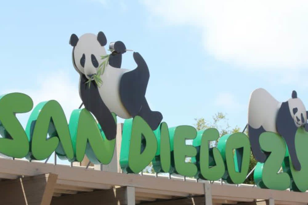 Entrance sign of San Diego Zoo featuring panda decorations.
