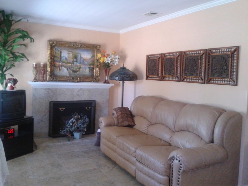 A cozy living room with a leather sofa, fireplace, and decorative elements.