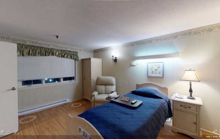 A neatly arranged bedroom with a bed, chair, and wall decorations.