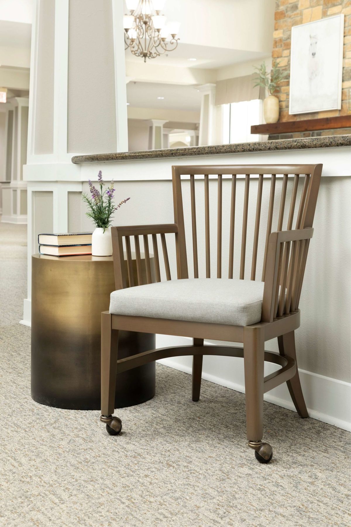 A wooden chair with a cushioned seat next to a small round table in a modern interior setting.