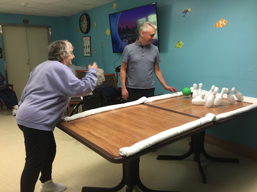Residents enjoying a fun bowling activity in a recreational setting.
