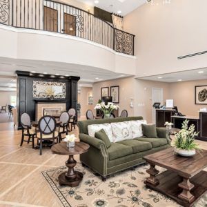 Spacious and elegant living room with an open dining area, featuring classic furniture and modern interior design.