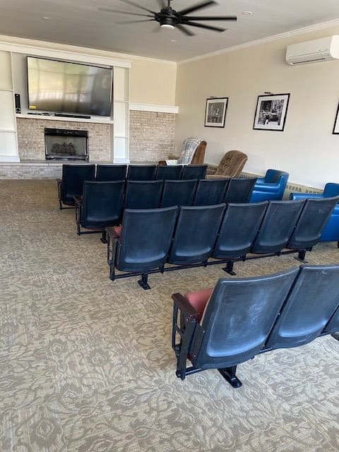 A waiting room with rows of chairs facing a television.