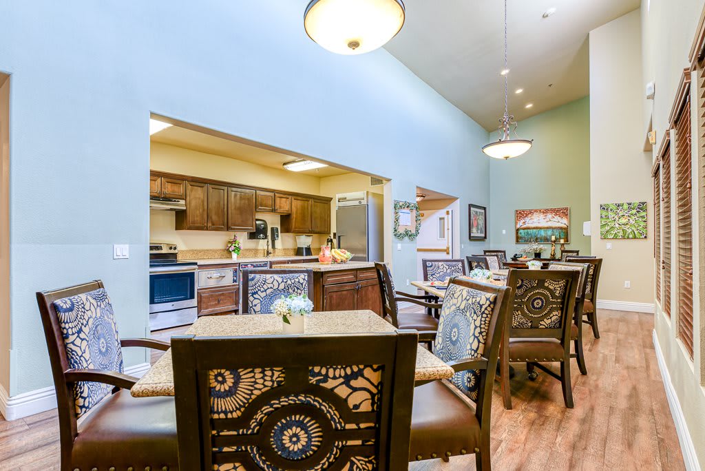 A cozy interior dining area with patterned chairs and a view of the kitchen.