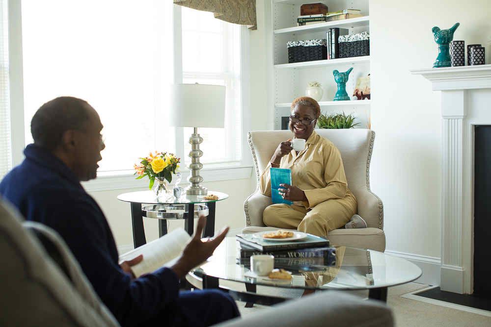 Two people enjoying a conversation in a cozy living room setting.
