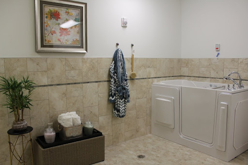 A tidy bathroom with a laundry area, featuring neatly hung towels and decorative art.