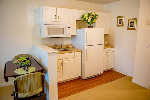 A cozy and modern kitchen featuring white cabinets, a refrigerator, and a microwave.