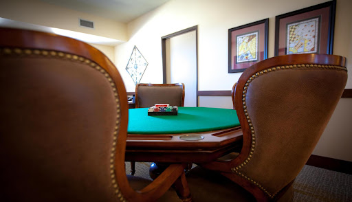 A neatly arranged poker table awaits players in a cozy gaming room.