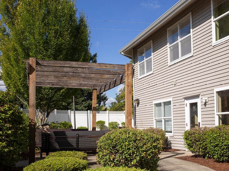 A backyard patio with a pergola and outdoor seating.