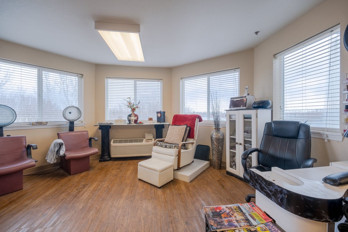 A cozy salon interior with multiple chairs and large windows offering a relaxing atmosphere.