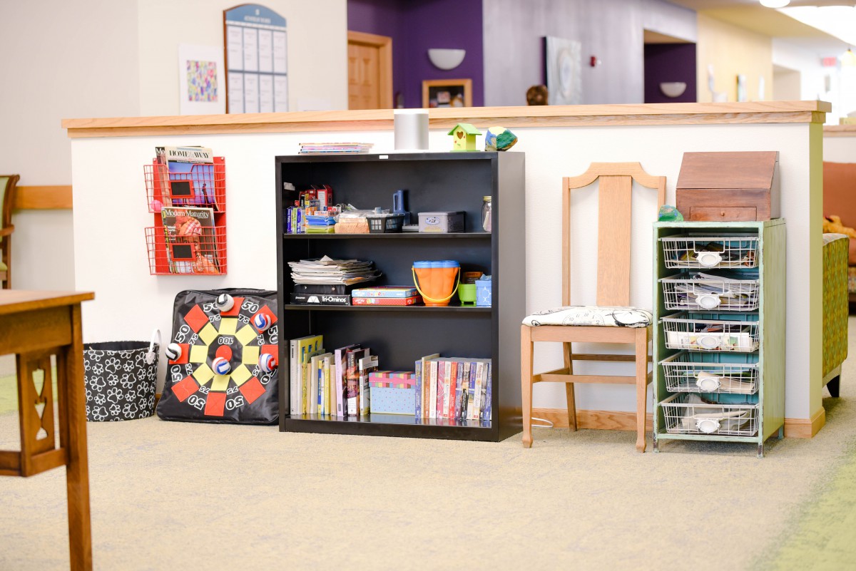 A children's room with a well-organized bookshelf filled with toys and books.