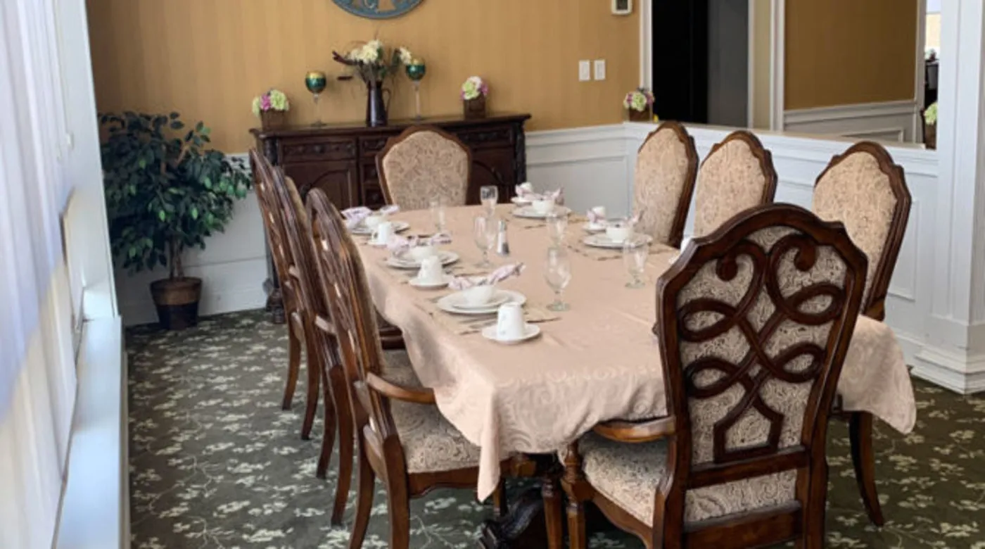 A formal dining room setup with an elegant table setting and decorative chairs.